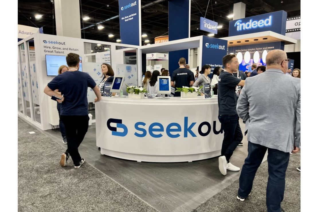 Crowd gathered at the SeekOut booth at a conference.