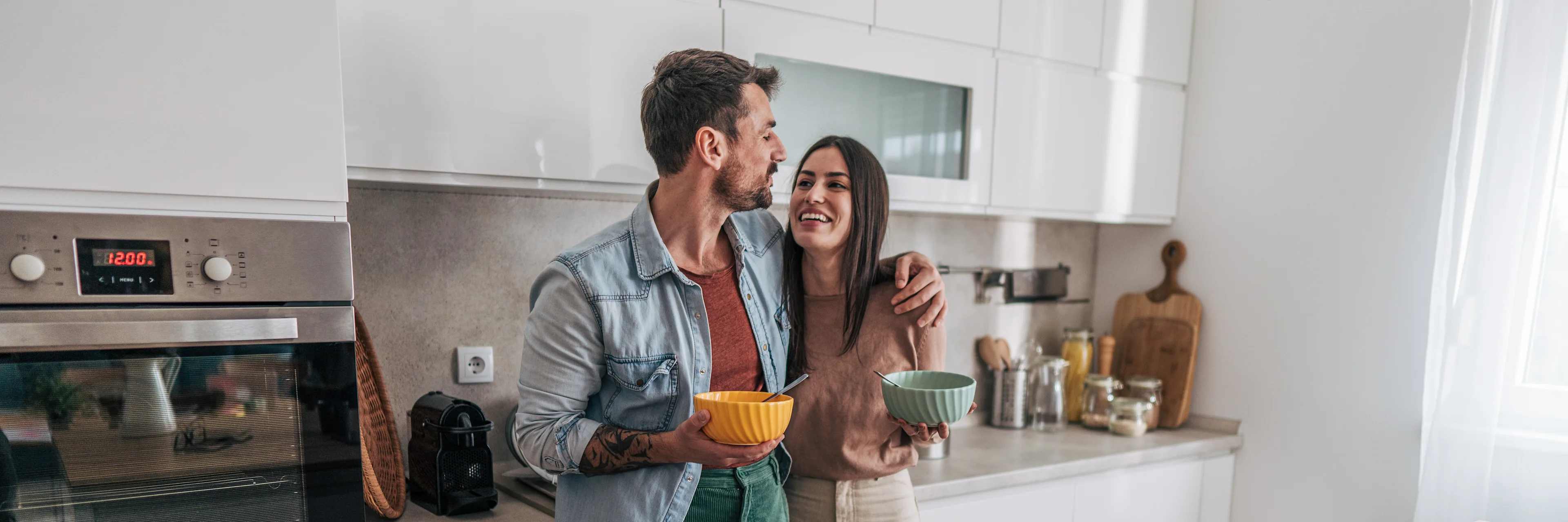 A couple in the kitchen having breakfast in a house.