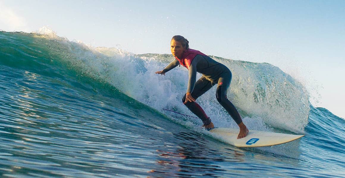 tjej surfar en våg portugal