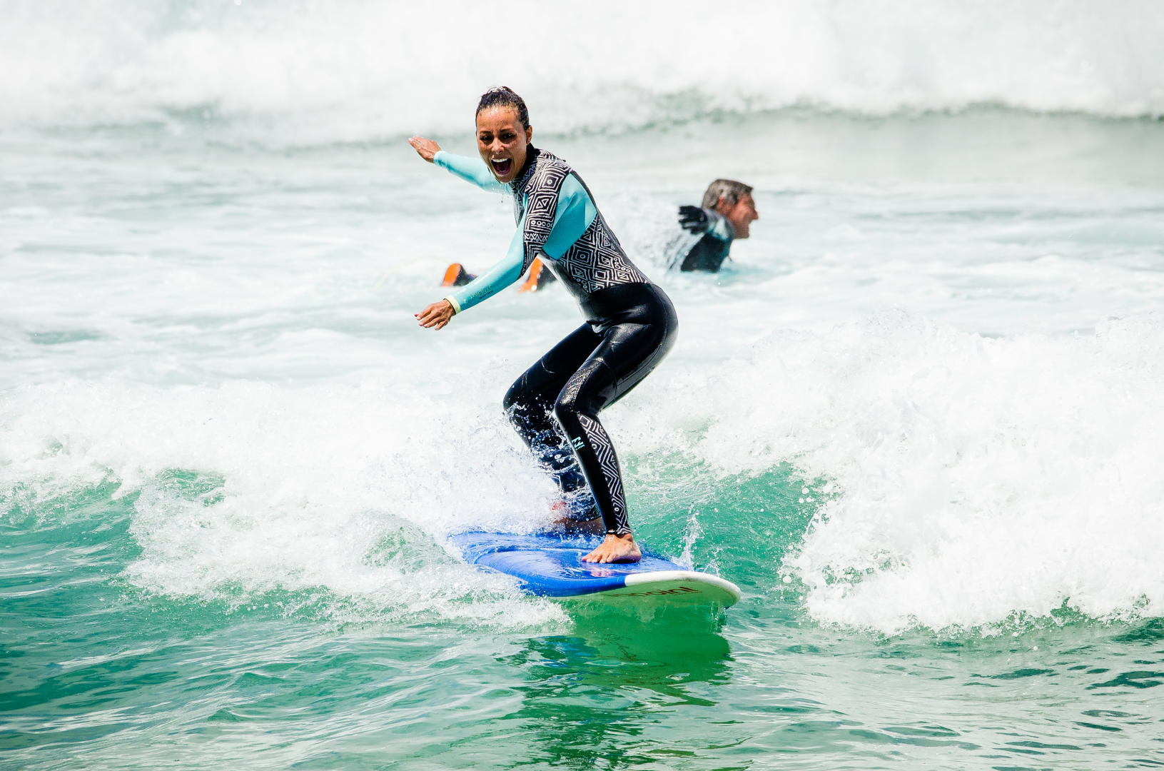 Beginner surfer girl catching wave smiling