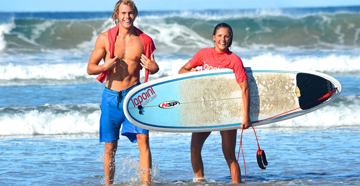 happy people holding surfboard