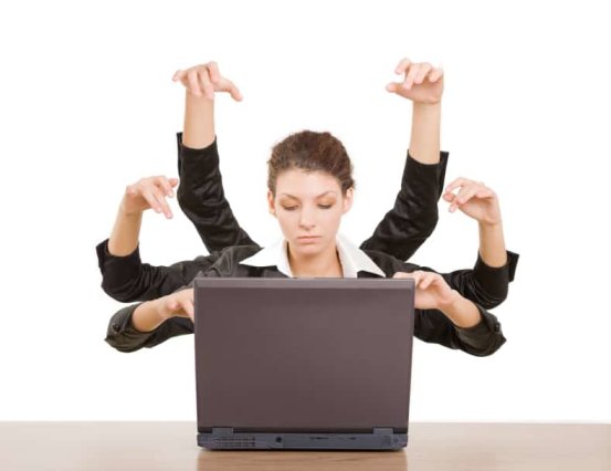 Business woman with 6 arms typing on laptop