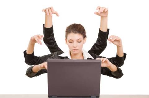 Business woman with 6 arms typing on laptop