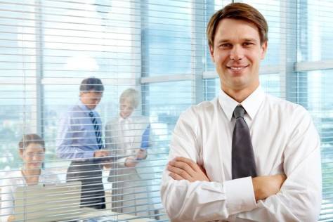Confident businessman smiling with arms crossed