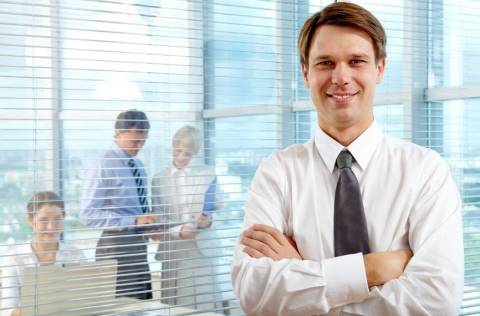 Confident businessman smiling with arms crossed