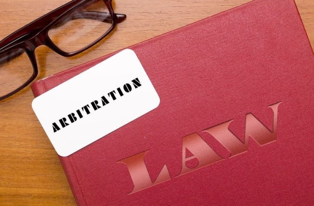 Law folder sits on a wooden table with glasses.