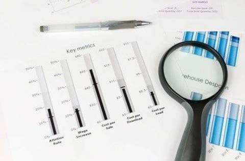 papers with key metrics and magnifying glass