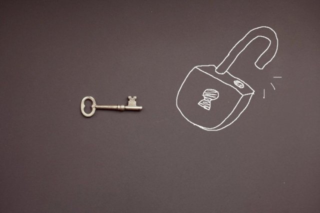 skeleton key next to chalkboard drawing of opened padlock