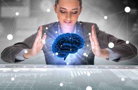 Woman holding imaginary brain above data workspace