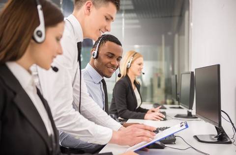 Manager explaining something to his employee in a call centre.