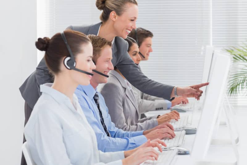 Call workers looking at their computers with a happy expression