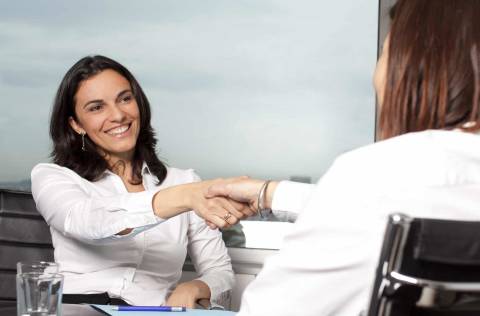 business women smiling and shaking hands