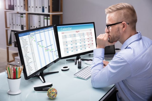 man at desk using scheduling software for call centers