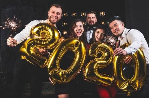 Group of people with sparklers and gold 2020 balloons.