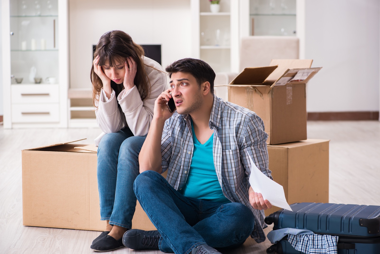 young couple receiving foreclosure notice letter, man on phone