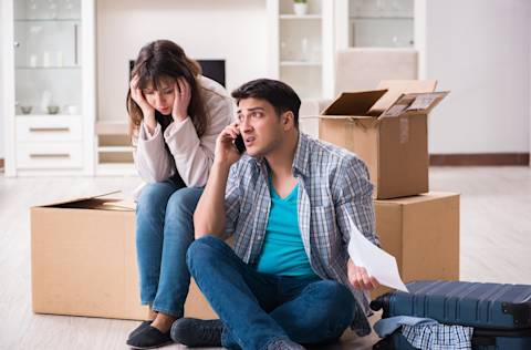 young couple receiving foreclosure notice letter, man on phone