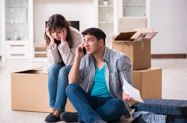 young couple receiving foreclosure notice letter, man on phone