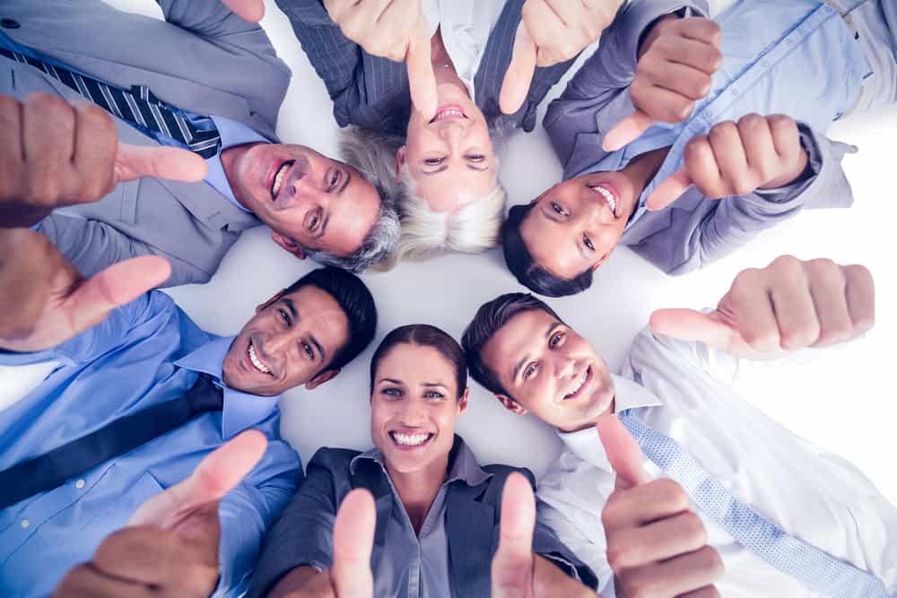 Business people gesturing thumbs up on white background
