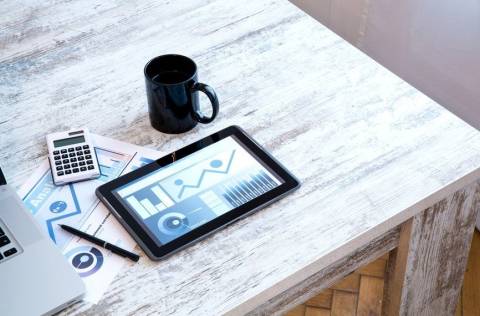 Coffee mug and iPad on desk