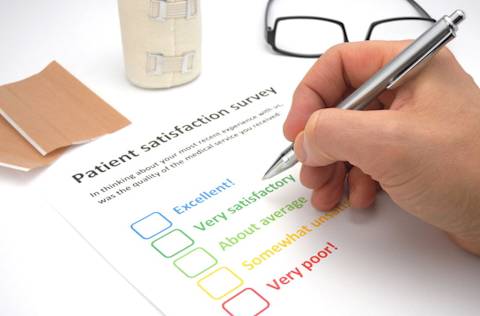 Mans hand filling out a patient satisfaction survey