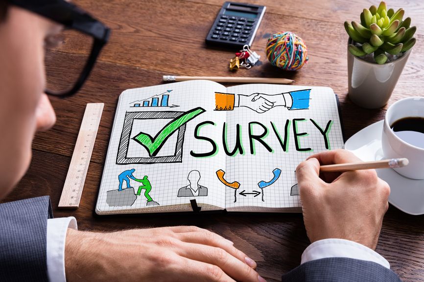 Man writes 'survey' in a notebook