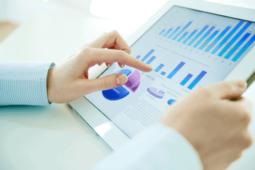 close up of womans hands reviewing analytics on tablet