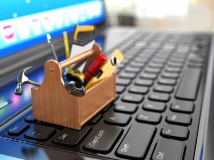 mini toolbox of tools sitting on laptop keyboard