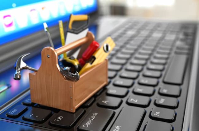 mini toolbox of tools sitting on laptop keyboard