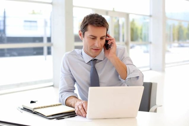business man on the phone in front of laptop