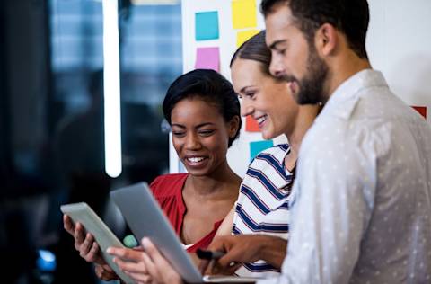 group of 3 looking at laptops