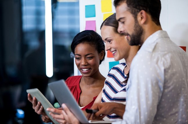 group of 3 looking at laptops