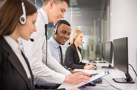 Manager explaining something to his employee in a call center.