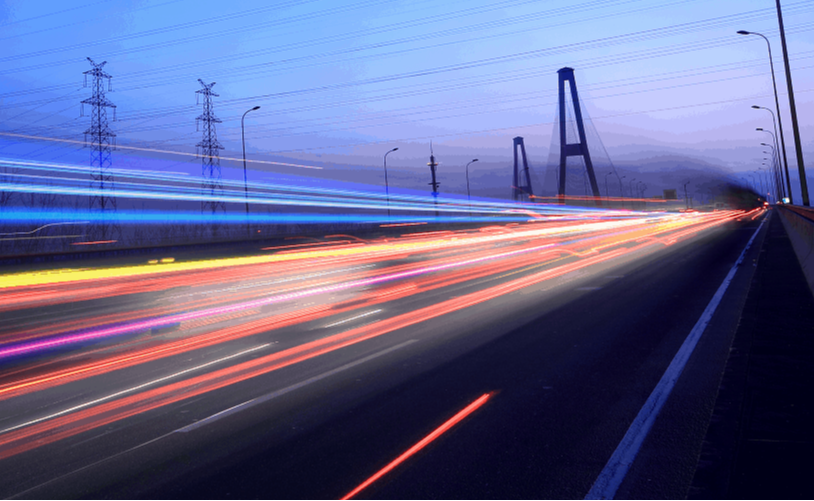 time lapse photo of busy street car lights blur by