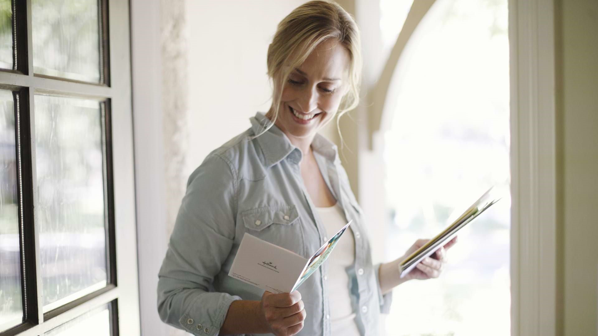 Woman Reading Greeting Card in Doorway ARTICLE HERO IMAGE
