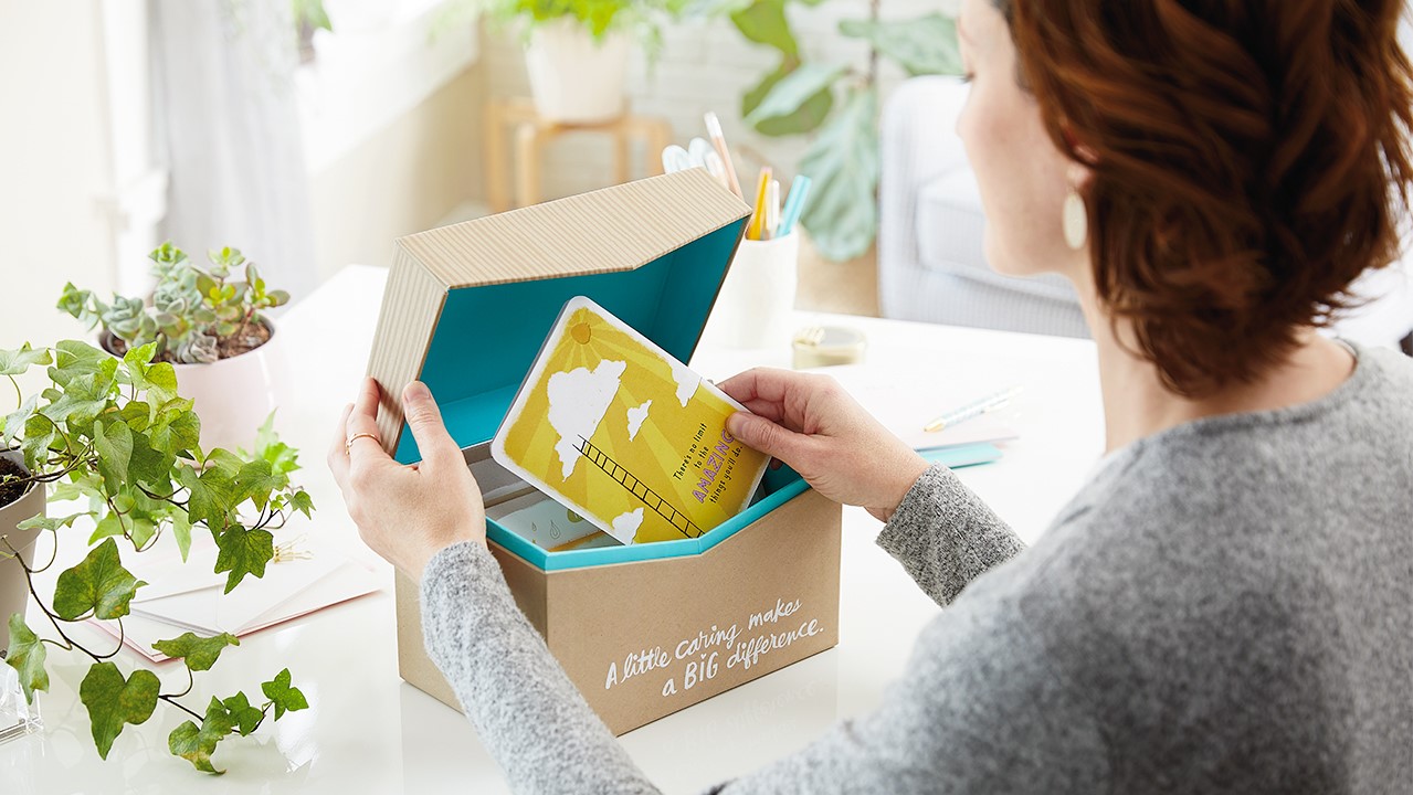Young woman pulling a Hallmark card out of a card organizer box