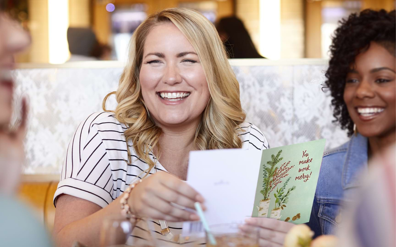 Women at lunch reading holiday card IMAGE