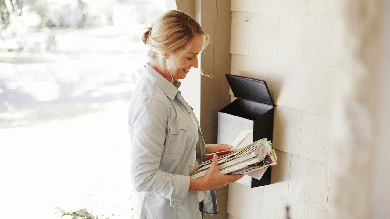 Female Getting Stack of Mail at Home Mailbox