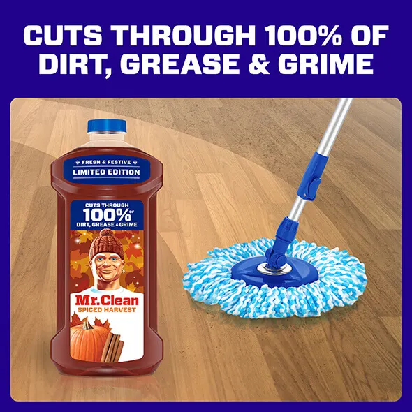 Mr Clean Spiced Harvest cleaning solution bottle beside a mop on wooden floor promoting effective dirt and grime removal