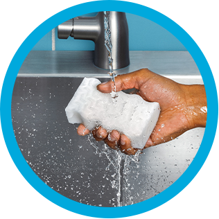 Washing Mr. Clean MagicEraser under a faucet