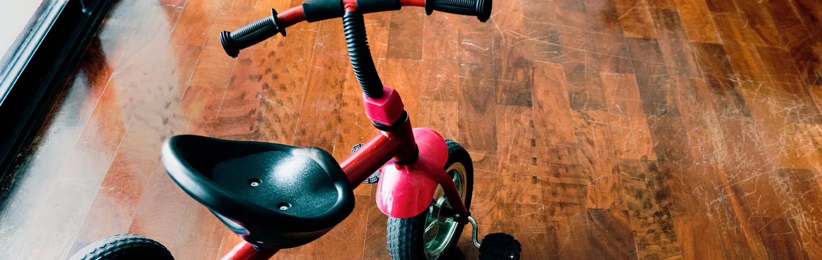 Children's bicycles on the wooden floor with scuffs