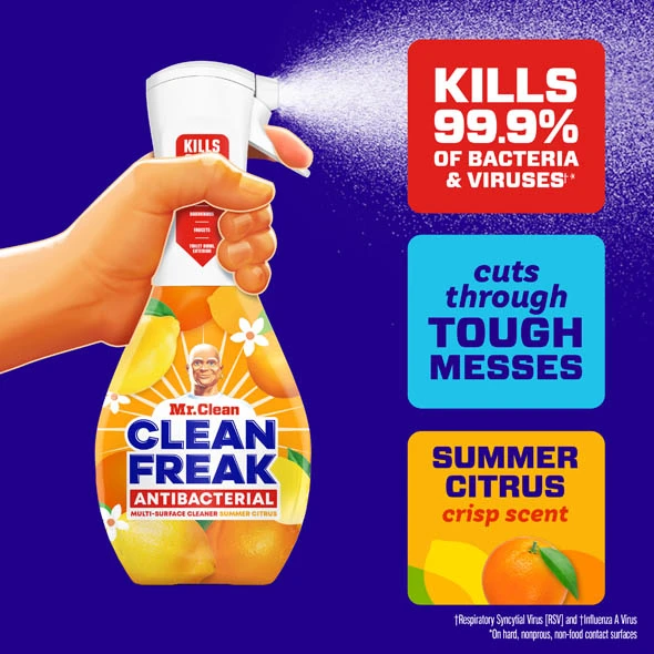 A hand holding a Mr. Clean Clean Freak Antibacterial cleaner spray bottle with summer citrus scent and bacteria-killing properties