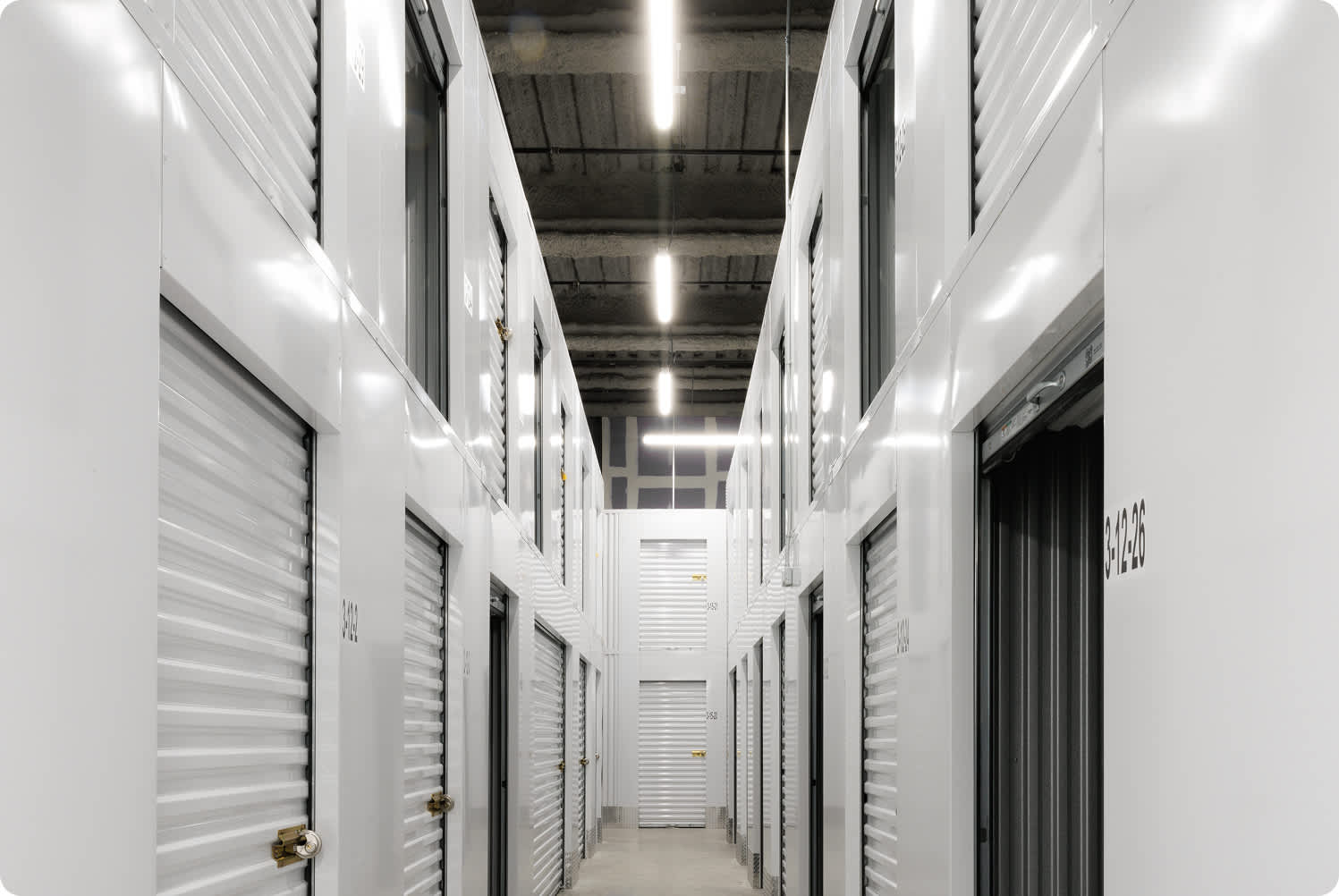 a self storage unit hallway with clean floors and clean storage unit doors
