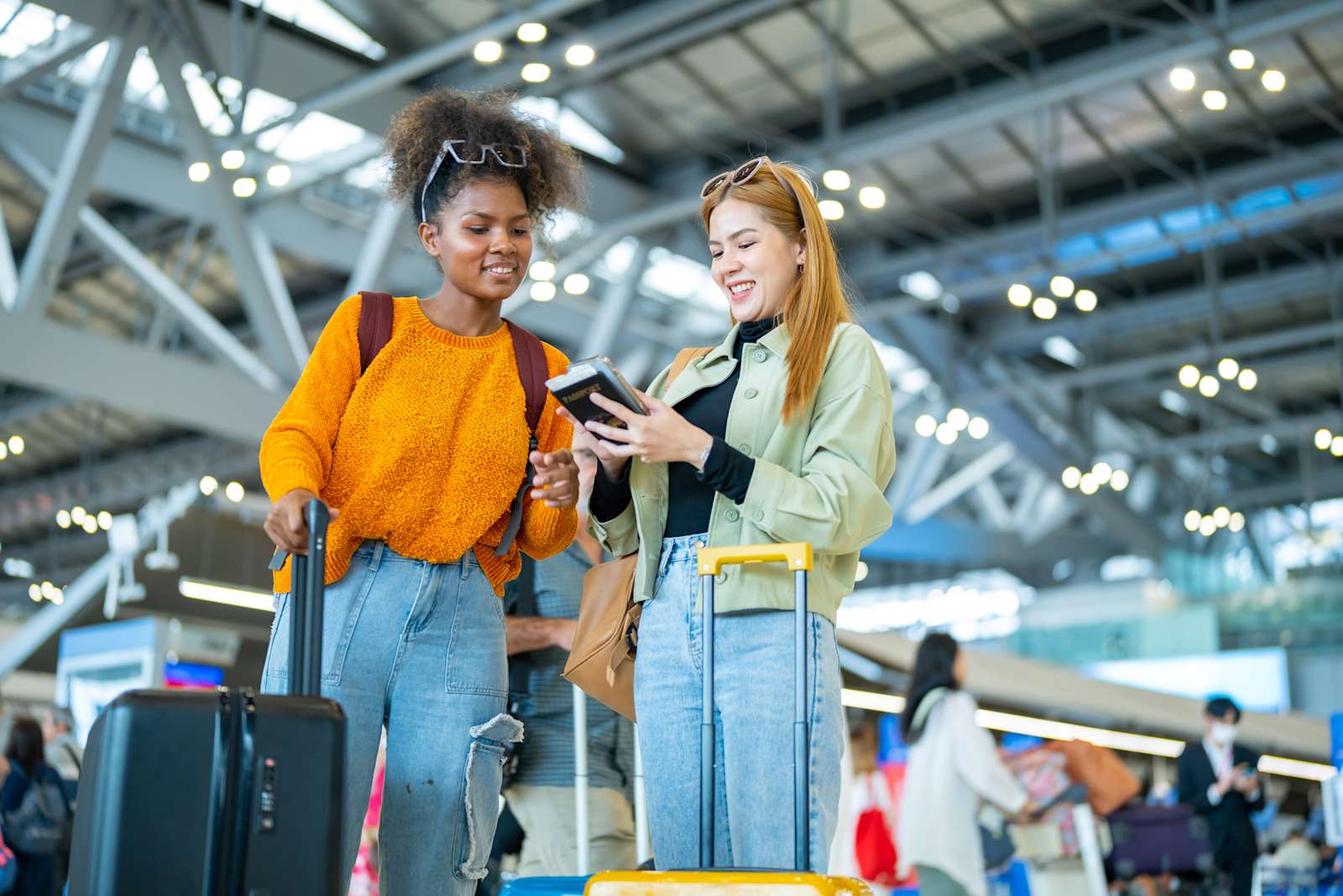 Two young women at the airport with suitcases and backpacks