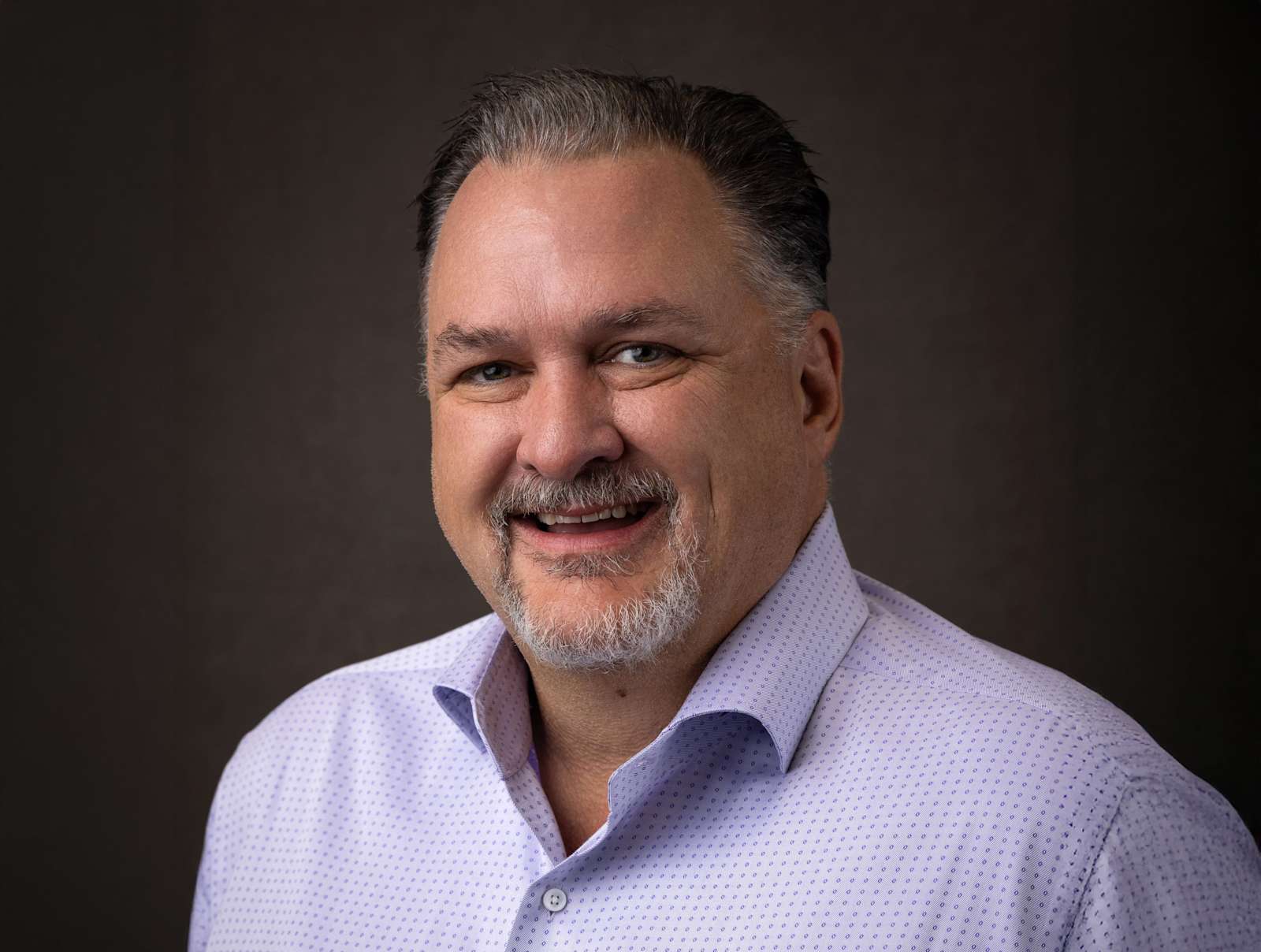 Professional headshot of a smiling Herby Bowman, VP of Third Party Management, in a light dress shirt.