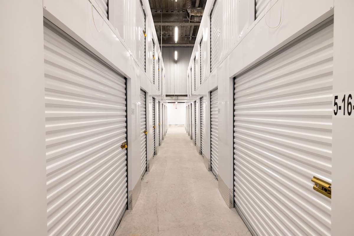 A well-lit hallway at Manhattan Mini Storage with rows of storage unit doors