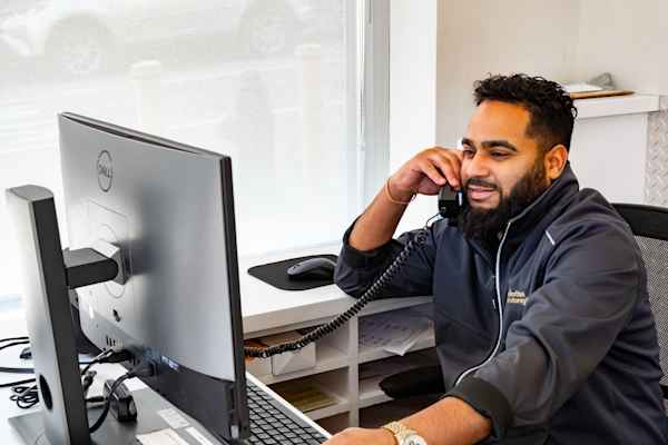 friendly employee at Manhattan Mini Storage on Dyckman St helping a customer over the phone