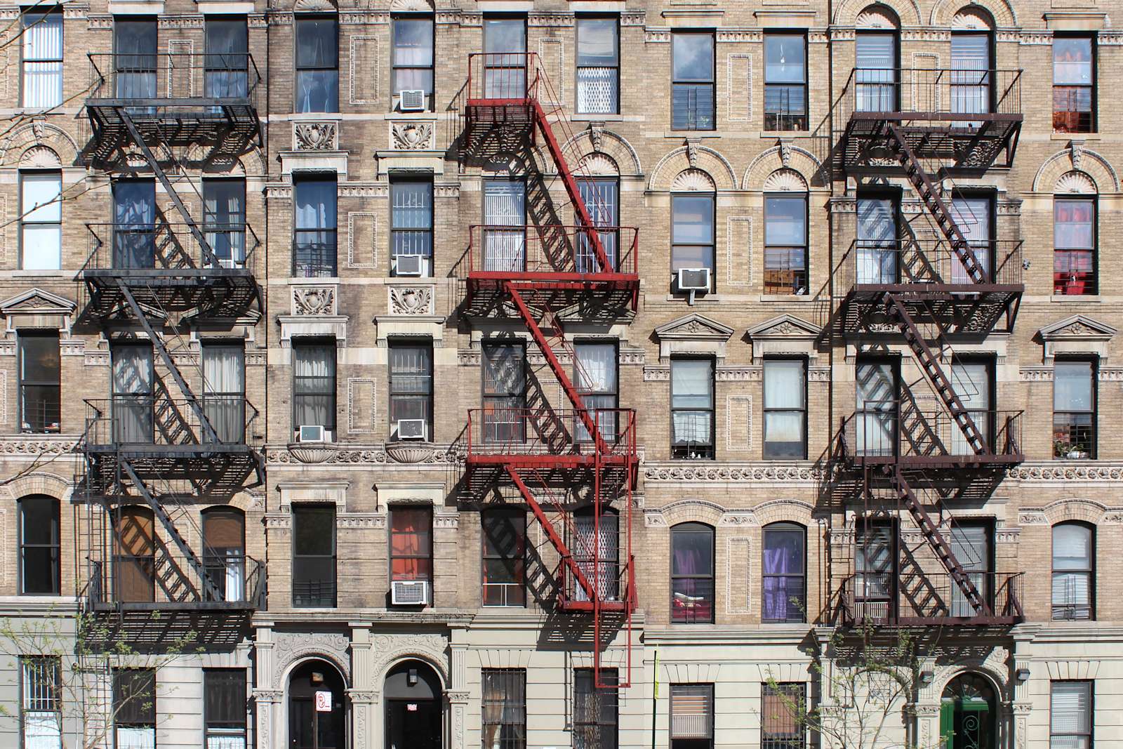 A view of NYC apartments with fire escapes and lots of windows