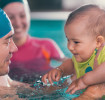 Baby in a pool wearing Swim Diapers