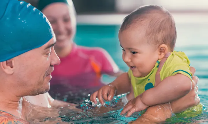 Baby in a pool wearing Swim Diapers