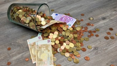 Glass full of coins and currency notes